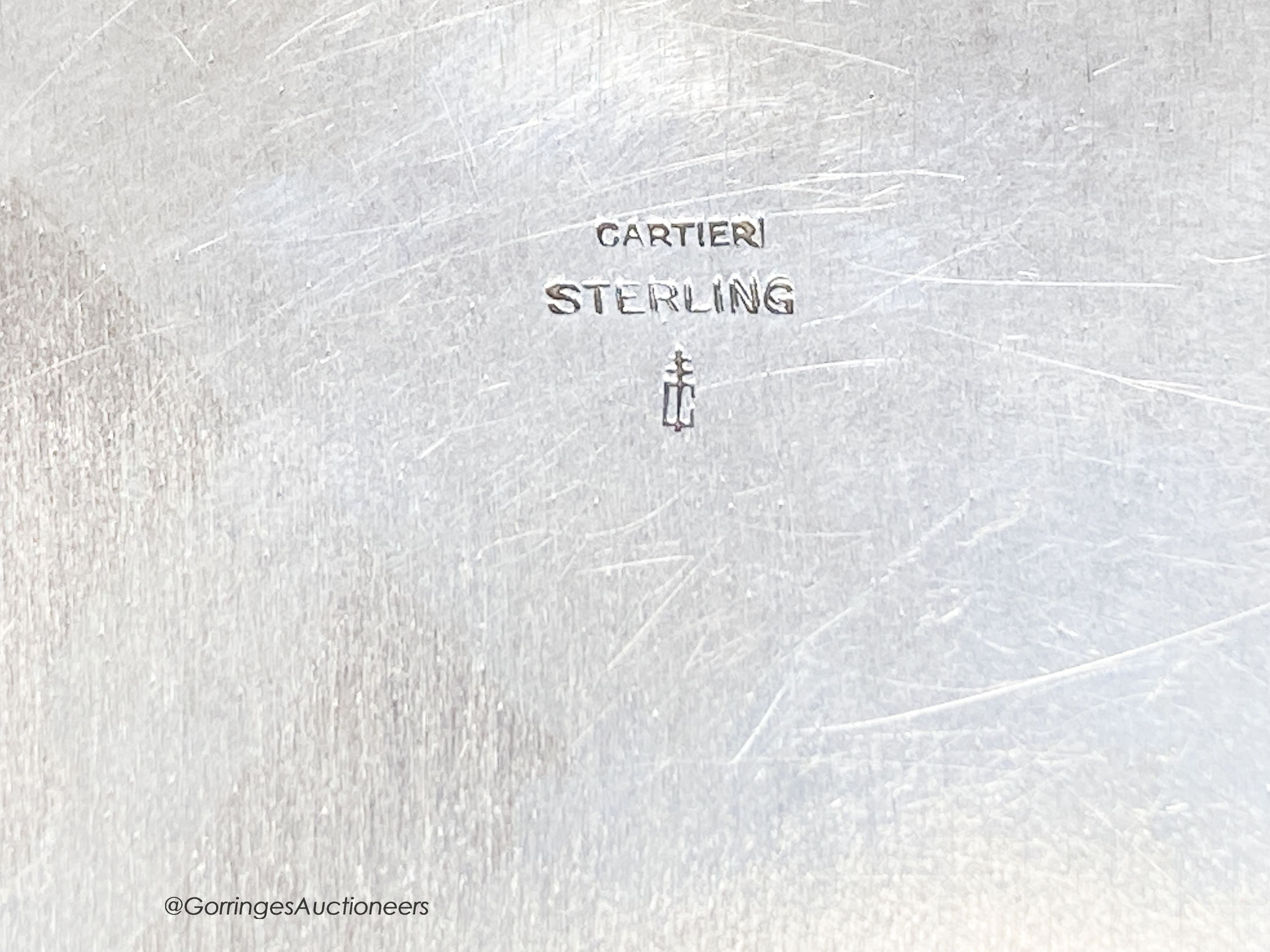 A white metal circular box and hinged cover, with enamelled applique modelled as a soldier, stamped sterling and bearing the stamp 'Cartier', diameter 73mm, gross weight 98 grams.